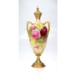 An Etruscan form twin handled Royal Worcester vase and cover, with spear finial, decorated with pink