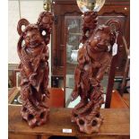 A pair of early 20th century Chinese rootwood table lamps, each carved as a smiling, standing figure