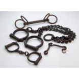 A set of 19th century iron slave fetters, 145cm, and two pairs of cuffs