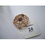 A late Victorian seed pearl and amethyst brooch, circular pierced lattice design with central