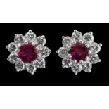 A pair of ruby and diamond cluster earrings, the circular cut rubies within a border of brilliant