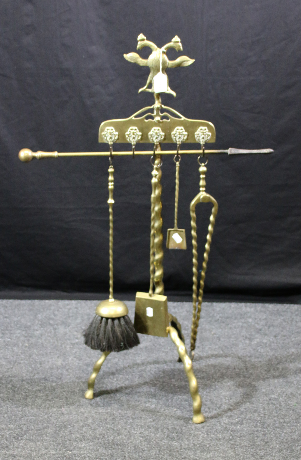 An early 20th century cast brass companion stand, with twin head spread eagle finial over five