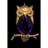 An owl brooch, the body set with a cabochon amethyst, and the eyes with circular -cut rubies