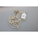 A three row uniform sized cultured pearl necklace to a plain barrel clasp, together with a three