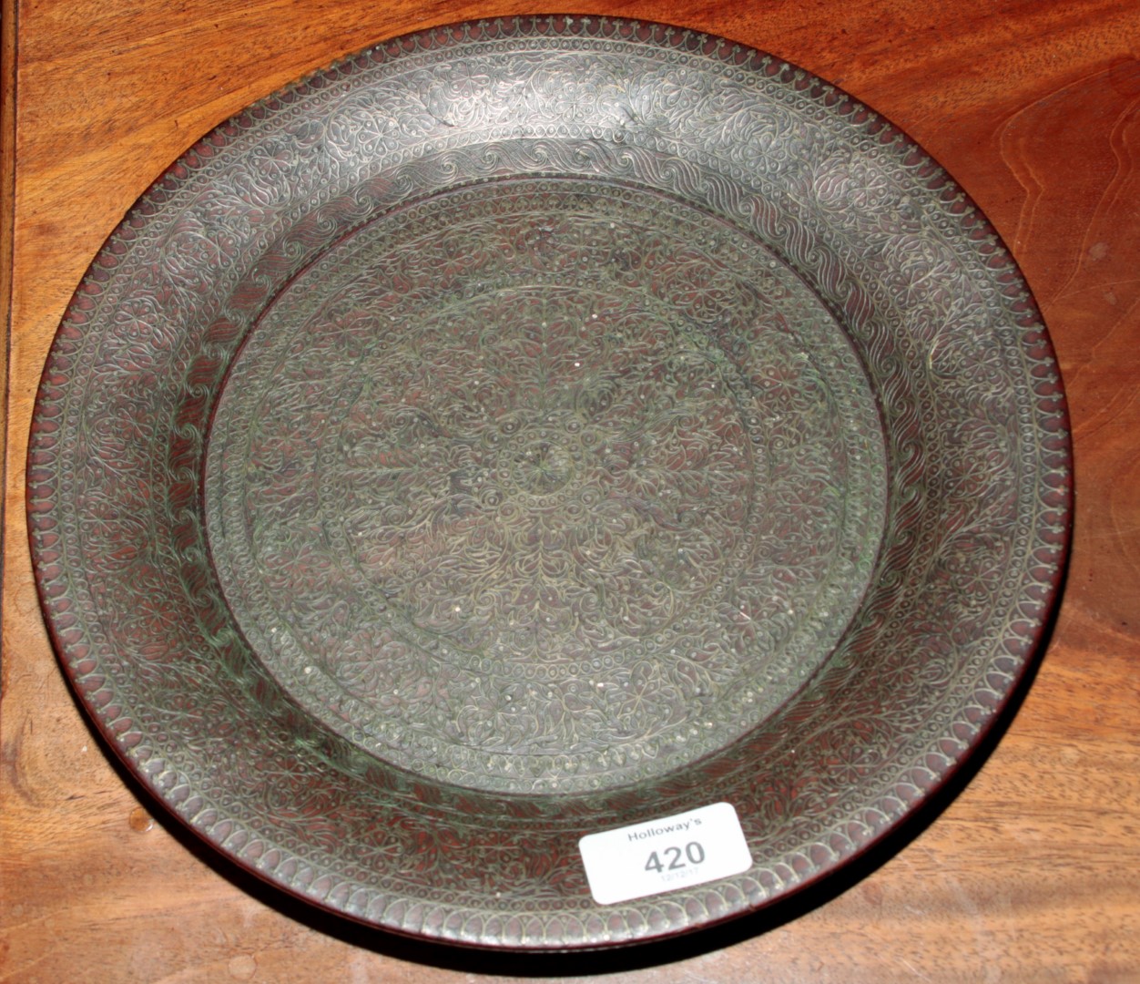 An early 20th century possibly Burmese hardwood plate, with intricate brass wire work decoration,