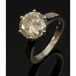A single stone diamond ring, the brilliant cut stone of brownish grey tint, in raised four claw