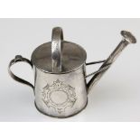 A Victorian white metal miniature watering can, with push fit cover and vacant cartouche, bearing