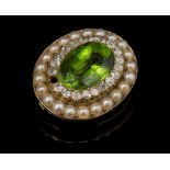 A late Victorian peridot, diamond and split pearl brooch, the oval cut peridot within a border of