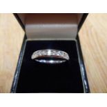 A 9ct white gold half eternity ring with thirteen channel set diamonds - size M 1/2, approx gross