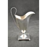 An early 19th century style helmet shaped silver cream jug, square base on ball feet, assay mark for