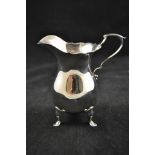 A Georgian style silver baluster cream jug with paw feet, Sheffield 1926, maker Walker & Hall -