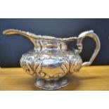 A late Georgian embossed silver cream jug, handle formed as a two headed bird, embossed acanthus and