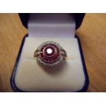 A 9ct gold ring set with central ruby surrounded by concentric rubies and diamonds, with diamond set