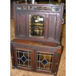 A hanging mirrored wall cupboard with blind fretwork, the cupboard enclosed by pair of lead glazed