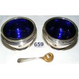 A boxed pair of silver salts with blue glass liners and matching spoons