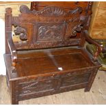 A carved oak hall settle