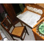 An antique washstand with marble top, together with a cane work bedroom chair