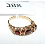 A garnet seven stone ring in 9ct gold setting