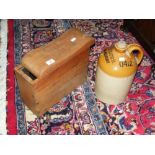 An old wooden caulker's stool with sliding top, together with an old stoneware bottle