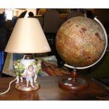 An old Geographia terrestrial globe, together with a ceramic table lamp