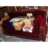 A 19th century carved mahogany framed settee with seat, back and armrests upholstered in red