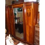 An antique French break-front wardrobe with fitted interior, having inlaid side doors and bevelled
