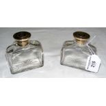 A pair of silver mounted cut glass cologne bottles