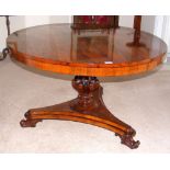 A Victorian oval rosewood tilt-top dining table with carved reeded "melon" centre column and