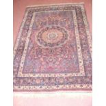 A 200cm x 130cm Isfahan rug with red ground and multi colour centre medallion and borders