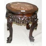 An ornately carved Chinese hardwood plant stand with marble inlaid top