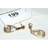 A pair of yellow metal earrings, each mounted with a brilliant cut diamond - total diamond weight