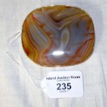 A large polished agate brooch in unhallmarked yellow metal mount