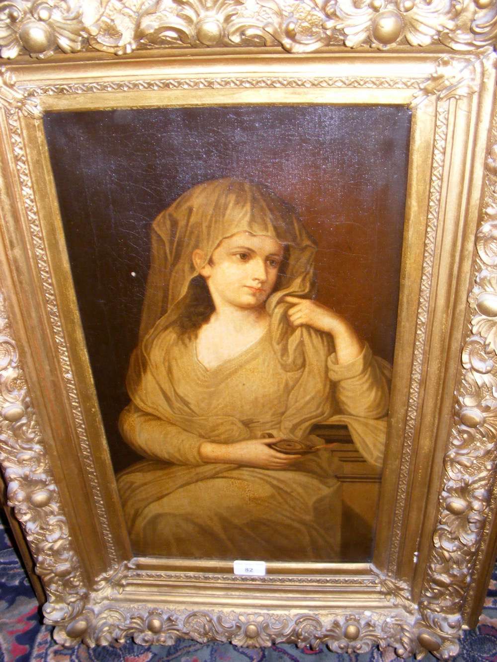 A 19th century - 56cm x 30cm - continental oil on canvas of lady holding lamp in decorative gilt