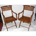 A pair of beech folding steamer chairs with slatted seats and back rests