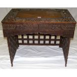 An ornately carved Chinese hardwood portable desk on foldaway lattice supports with two drawers to