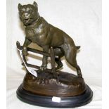 A reproduction bronze figure of a fierce dog up on a fence - stamped C Valton - 30cm high overall