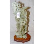 A Chinese carved green hard stone group of birds in a bush on fitted carved wood base - 35.5cm