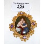 An oval painting on porcelain - Mother and child - in 15ct gold amethyst set filigree brooch mount