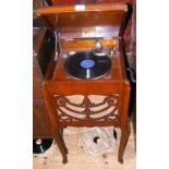 An old wind-up gramophone on cabriole supports with records