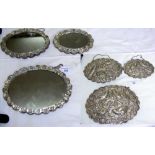 Set of three graduated shaped oval hanging mirrors, the backs embossed with birds and foliage and