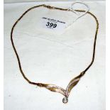 A 9ct gold necklet with integral V-shaped diamonds and having .5 carat diamond drop