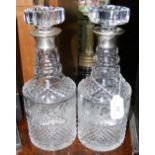 A pair of cut crystal decanters with silver mounts