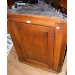 A 19th century oak hanging corner cabinet enclosed by a panelled door