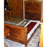 An antique French single bedstead with gilt mounts and cross banded walnut head and foot boards