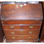 A Georgian oak well top bureau on shaped bracket feet and apron