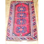 A 133cm x 78cm red ground Middle Eastern rug