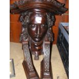 An ornately carved hardwood wall bracket in the form of a classical female head and a pair of
