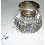 A 9cm diameter ribbed cut glass desk inkwell with silver mount and hinged lid