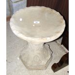 A decorative concrete birdbath on stand