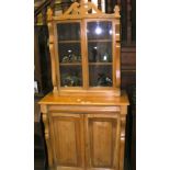 A pine bookcase/cupboard with glazed upper section